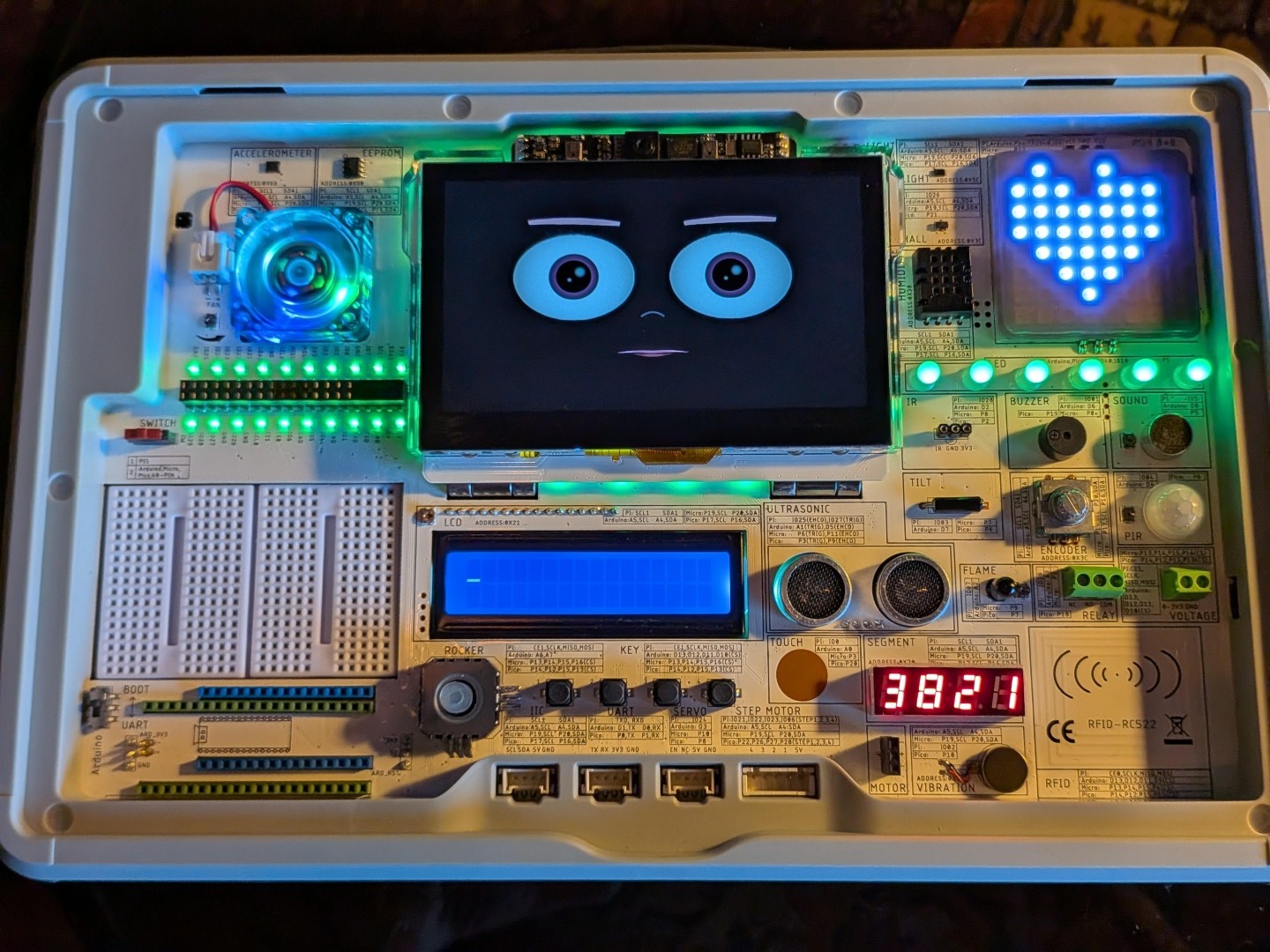 Top-down view of Sparkle's open CrowPi 3 showing all 30+ labeled sensor modules, the face screen, the LED heart, and the LCD