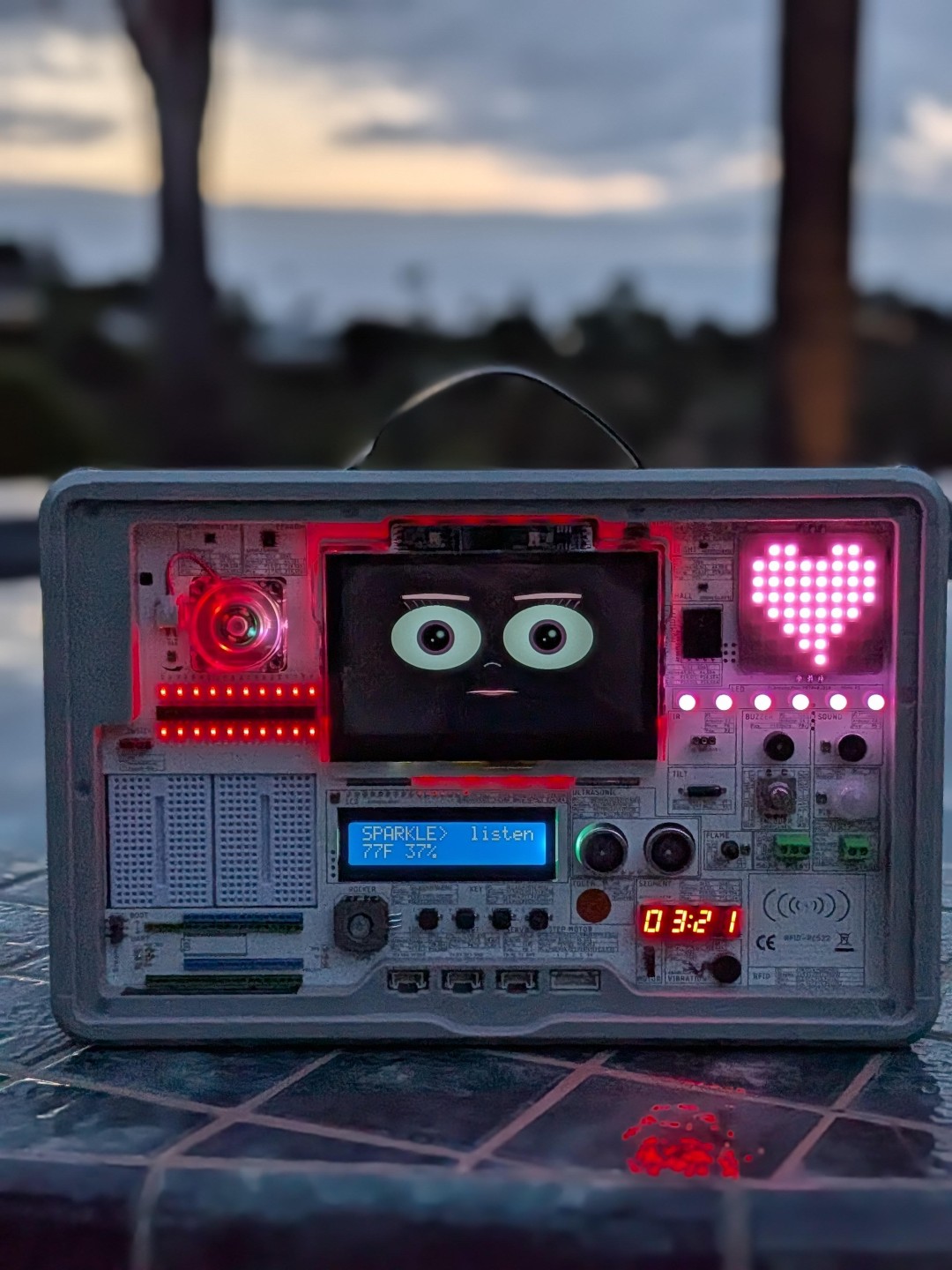 Sparkle at dusk by the pool, LCD reading SPARKLE listen 77F 37%, LED heart pulsing magenta