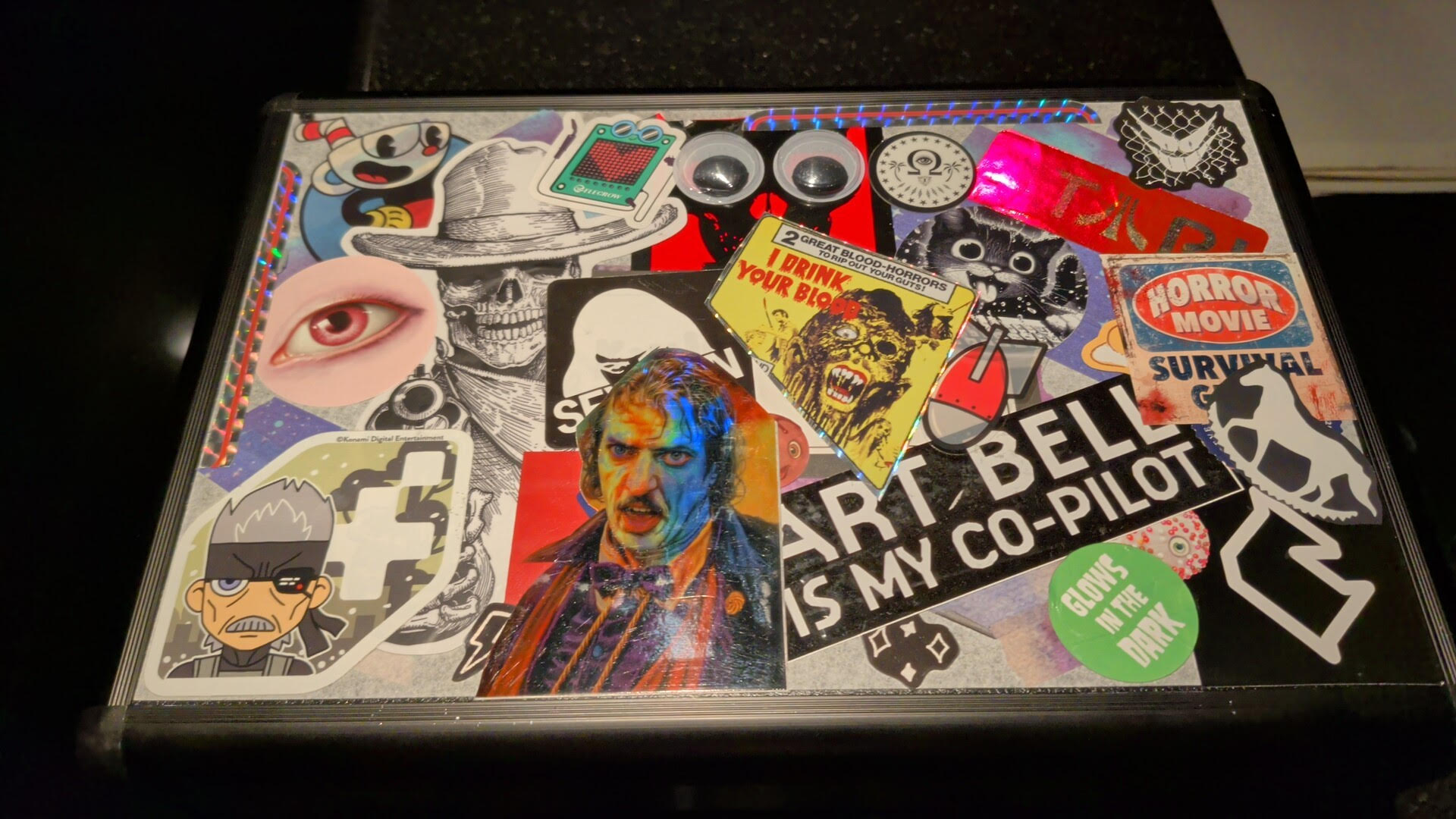 Top of Sparky's case, covered in stickers people have added over time - horror, retro gaming, googly eyes